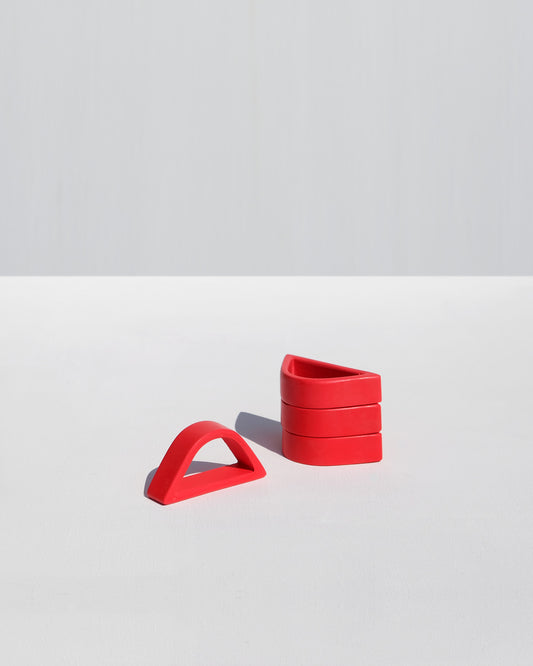 Set of red arched napkin rings handcrafted by Alkaline Shop in South Africa, perfect for elegant table settings and modern dining decor