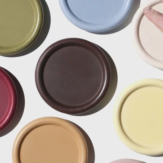 Assorted colorful stackable coasters on a white background