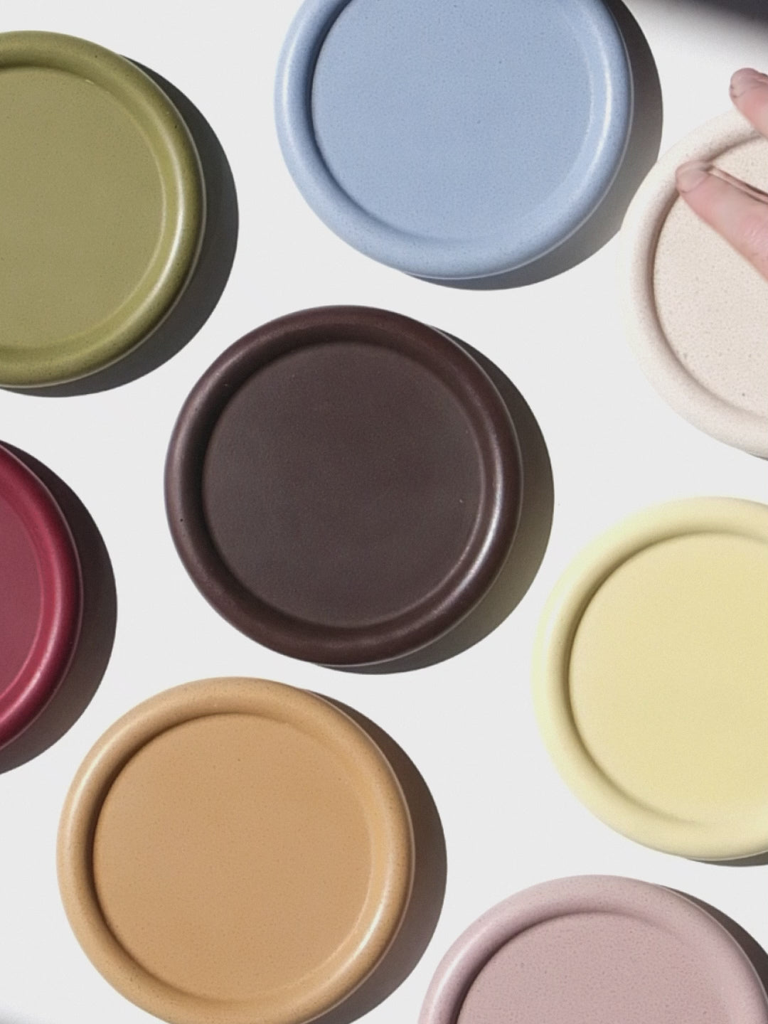 Assorted colorful stackable coasters on a white background
